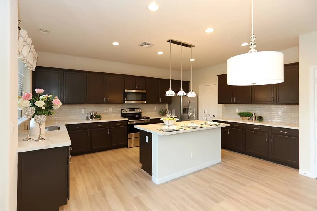 Remodeled kitchen with white island and dark cabinets from the Cost Plus 20 photo collection