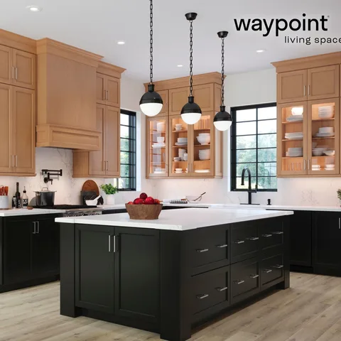 The warmth of Maple Cider paired with deep Painted Black base cabinets gives this kitchen the perfect balance of elegance and coziness. Glass-front cabinet doors with interior ligh