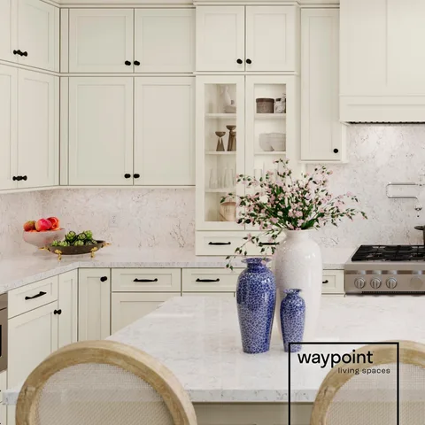 Bright, creamy-colored cabinetry paired with glass inserts is perfect for creating a welcoming, custom-feeling living space.