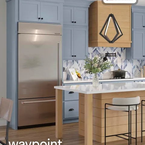 This kitchen pairs the clean, structured lines of partial overlay shaker cabinet doors with a modern mix of soft blue tones and warm wood accents. The result is a space that feels 