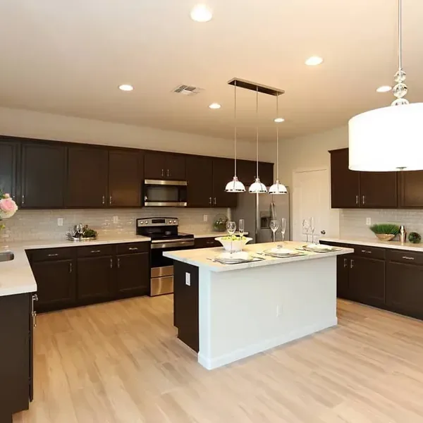 Wood-look flooring beside dark kitchen cabinets and a white island – Flooring Installation in Apache Junction, AZ